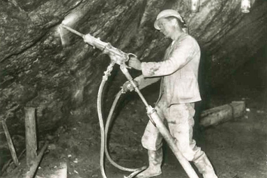 Ein Mann stemmt mit einem Presslufthammer Gestein aus dem Felsen | © Markt Bodenmais